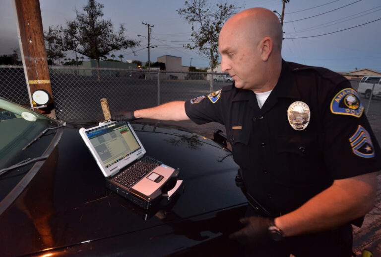 automovil estacionado con policia y huellas digitales