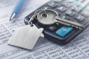 casa y llave sobre documentos financieros