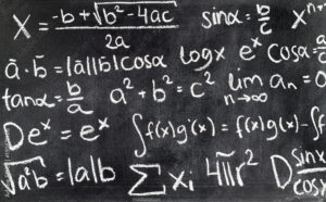 mano escribiendo ecuacion matematica en pizarra