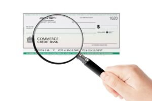 mano sosteniendo tarjeta bancaria y lupa