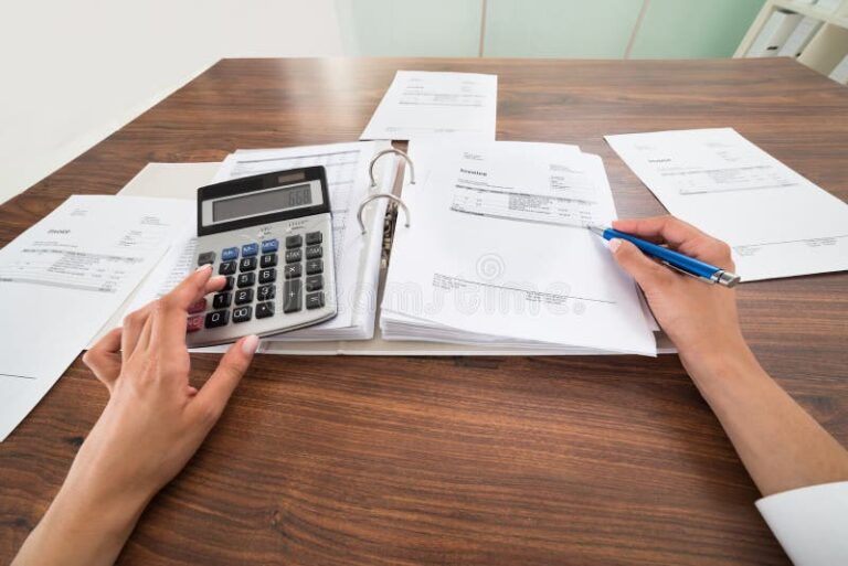 manos calculando con calculadora y facturas