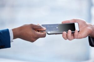 manos con celular y tarjeta bancaria digital