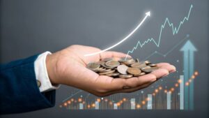 manos con monedas y graficos financieros digitales