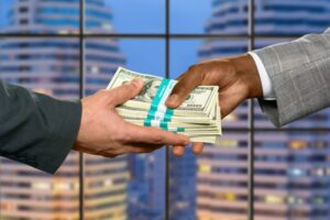 manos entregando dinero prestamo bancario deuda