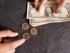 manos intercambiando monedas y billetes