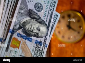manos sosteniendo billetes y reloj vintage
