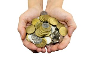 manos sosteniendo monedas y billetes diversos