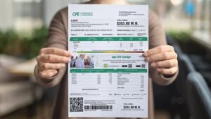 manos sosteniendo recibo de luz cfe