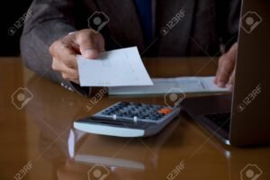 manos sosteniendo un cheque y calculadora bancaria