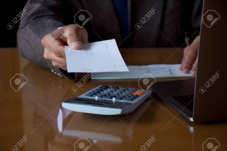 manos sosteniendo un cheque y calculadora bancaria