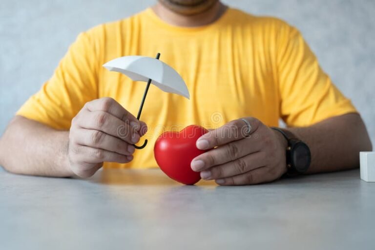manos sosteniendo un corazon protegido por paraguas