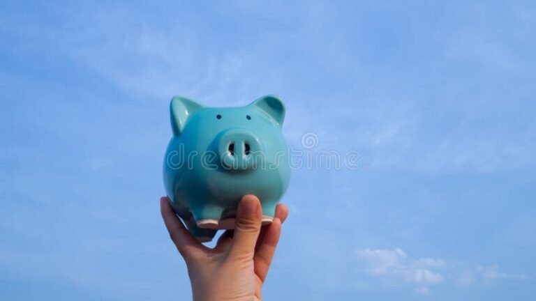 Qué es una caja de ahorro según la Ley Federal del Trabajo 2 manos sosteniendo una hucha de cerdito azul