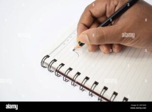 persona escribiendo en cuaderno con lapiz