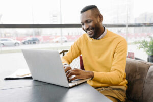 persona feliz usando laptop en cafe
