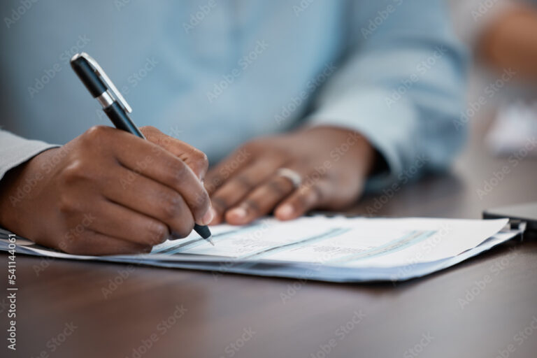 persona firmando documento oficial en escritorio
