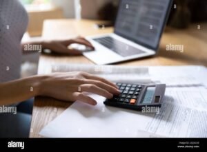 Cómo puedo pagar lo que debo en Buró de Crédito fácilmente 4 persona revisando finanzas con calculadora portatil