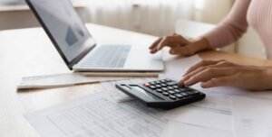 persona revisando reporte crediticio con calculadora