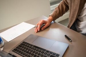 persona trabajando con documentos y laptop