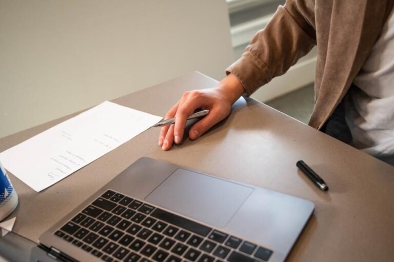 persona trabajando con documentos y laptop