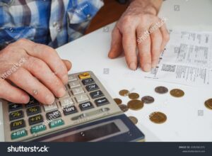 persona usando calculadora con factura y monedas