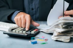 persona usando calculadora y revisando finanzas