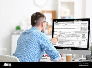 persona usando computadora con formularios fiscales