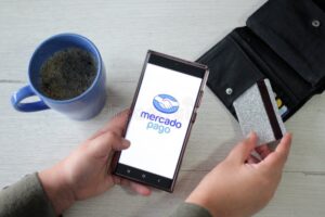persona usando smartphone con tarjeta mercado pago