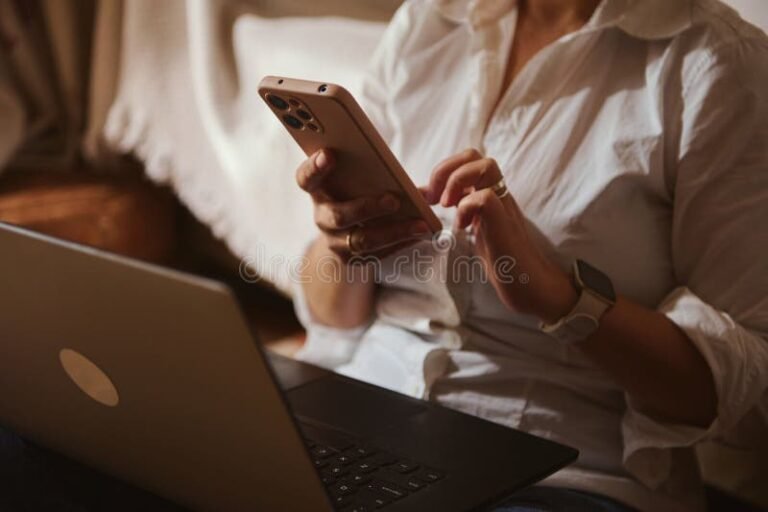 persona usando smartphone y computadora en casa