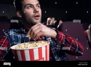 personas disfrutando palomitas en cine lleno