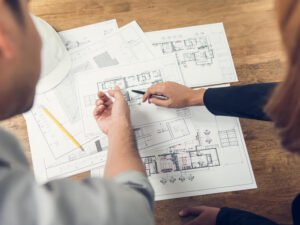 Cómo Comprar Terreno y Construir Casa con Crédito Infonavit 12 personas revisando planos de construccion exteriores